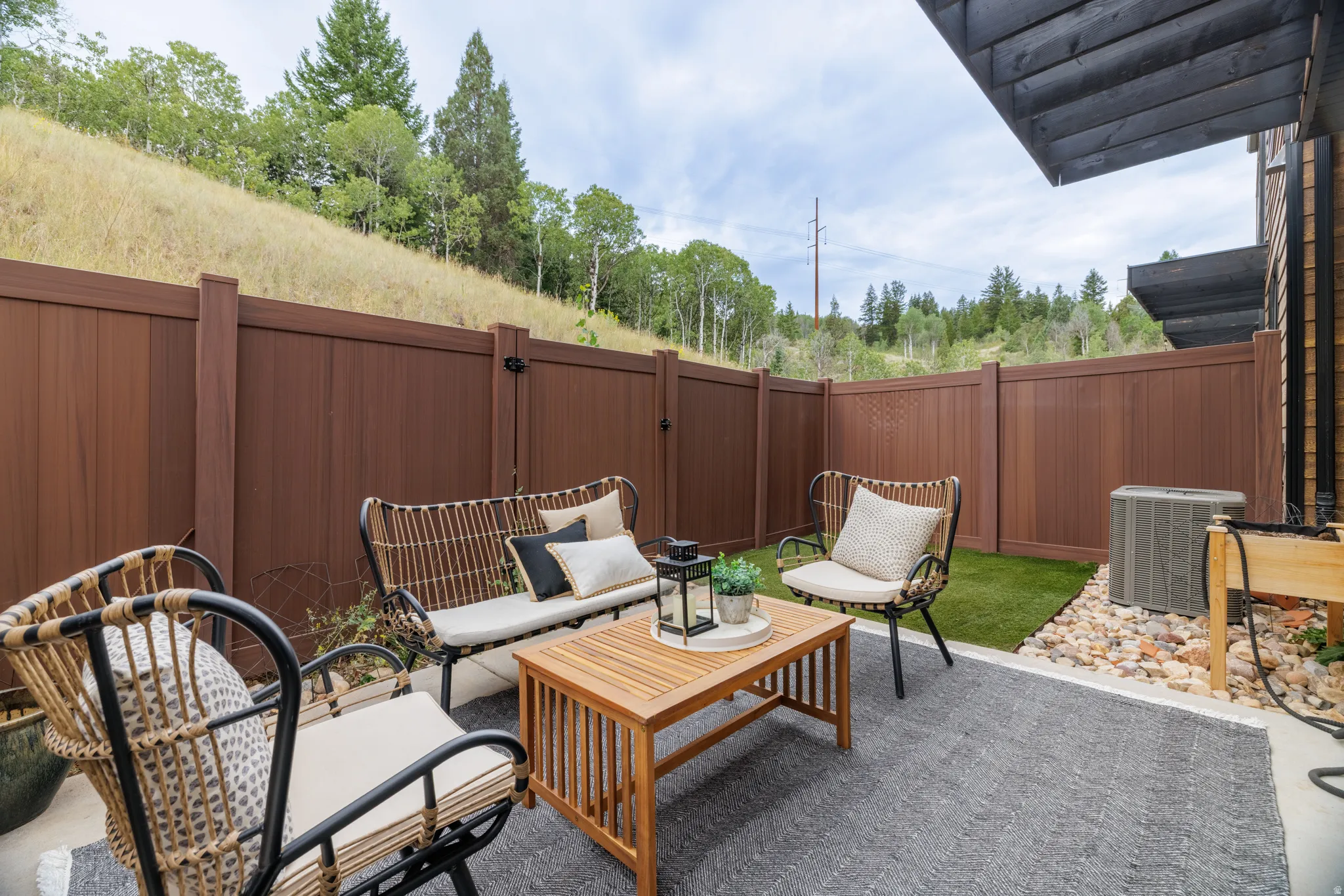 Private outdoor patio featuring a privacy fence, concrete flooring, and an artificial turf section