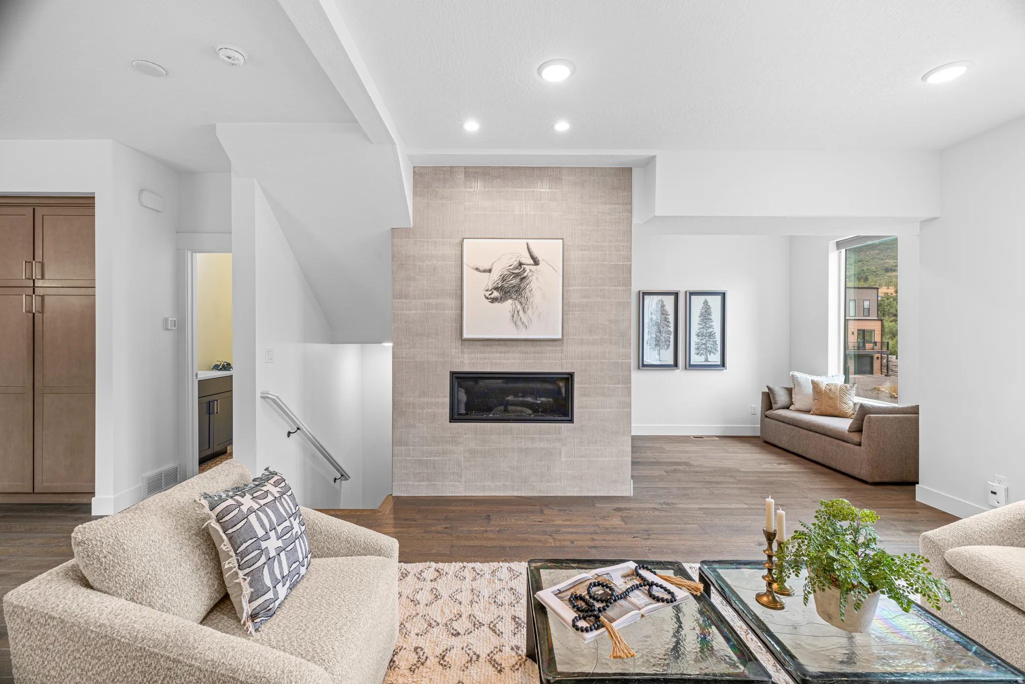 Built-in fireplace with tile surround, recessed lighting, wood-finish flooring, and built-in cabinetry