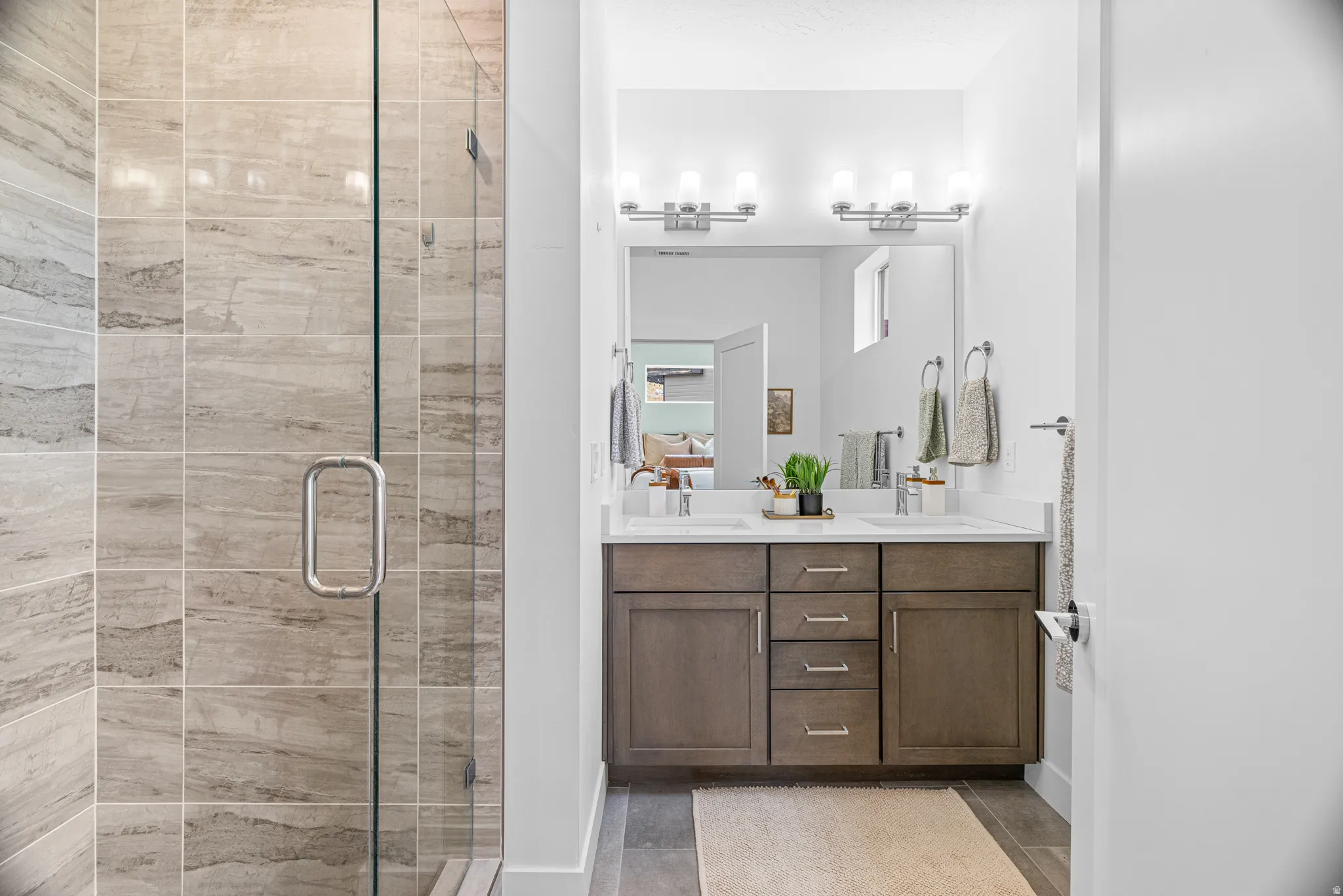 Walk-in shower with full-height tile surround, clear glass enclosure, and chrome hardware