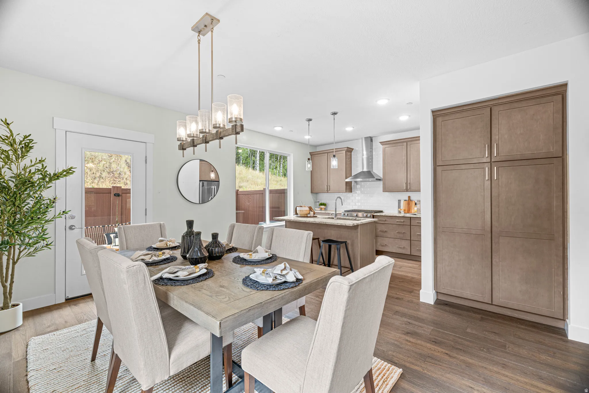 Wood-finish flooring throughout, with a contemporary linear chandelier over the dining area