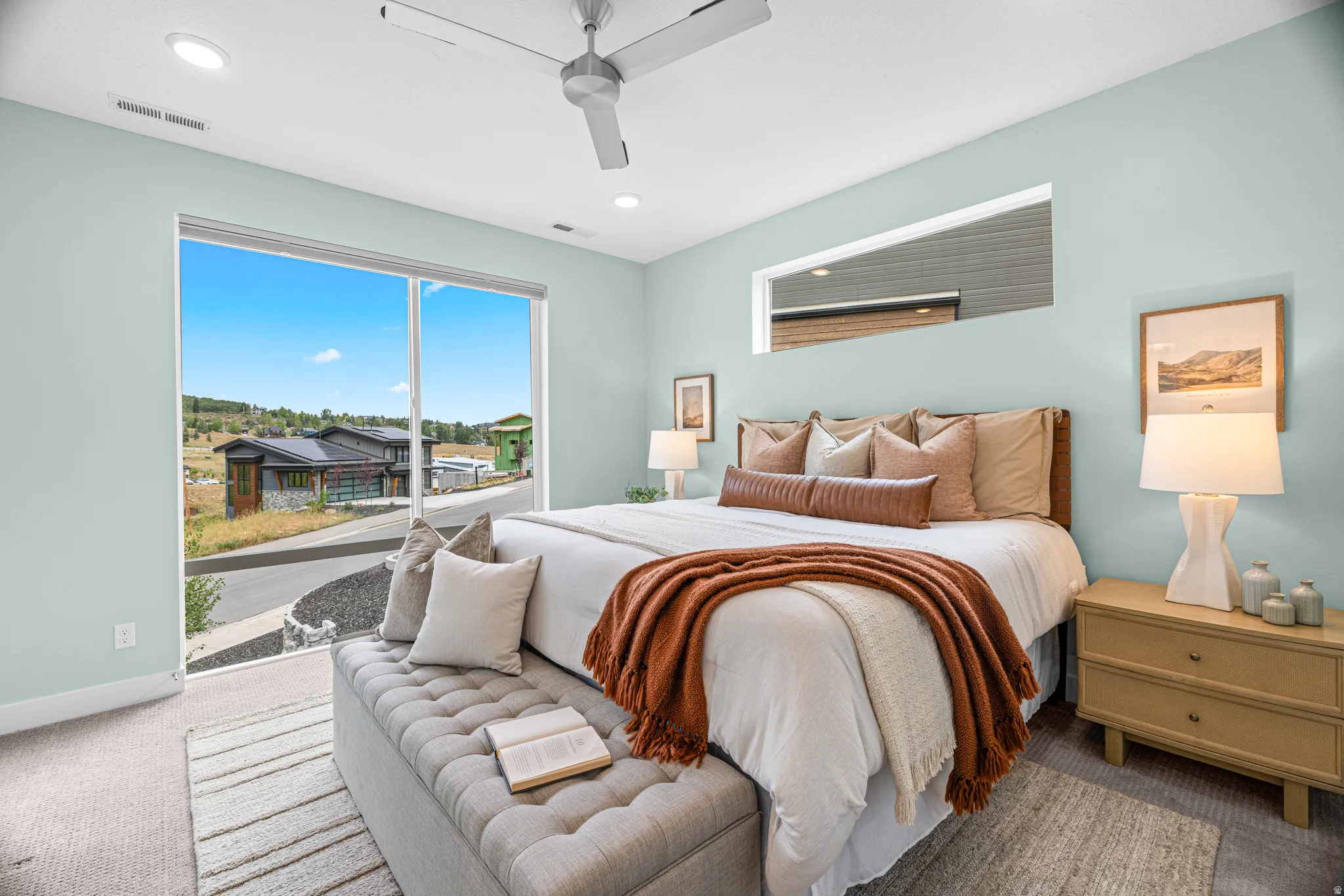 Expansive full-height window, transom window, recessed lighting, and a ceiling fan
