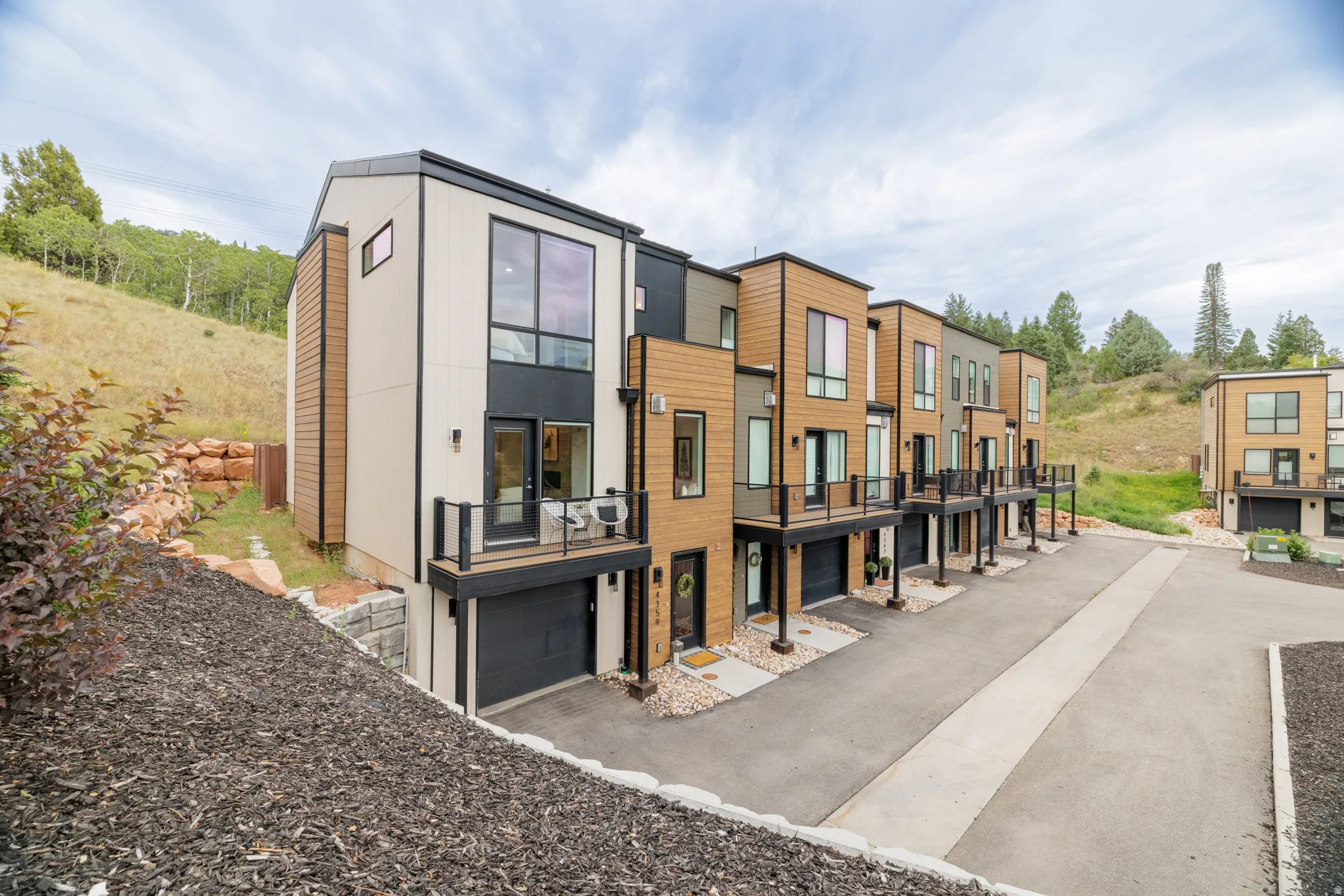 Modern architectural design with multi-tone siding, private balconies, and integrated garages