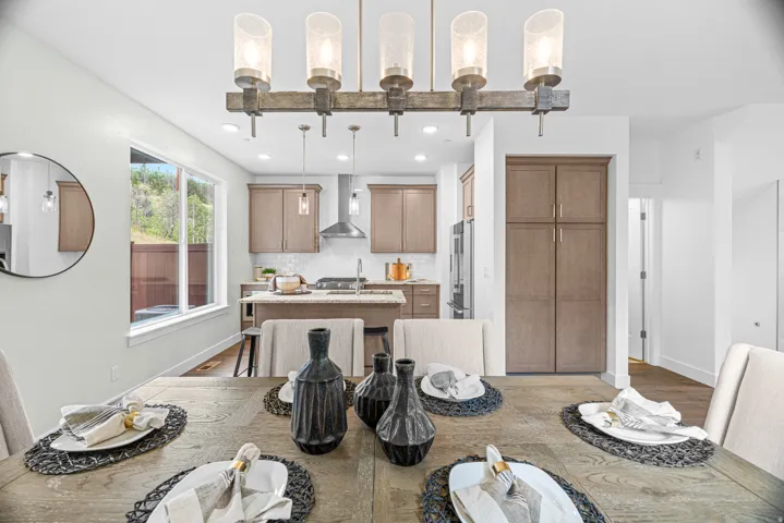 Open-concept living space with a contemporary linear chandelier and wood-finish flooring
