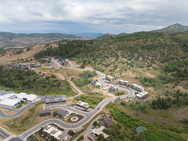 Mountainous terrain with lush green foliage, winding roads, and residential structures