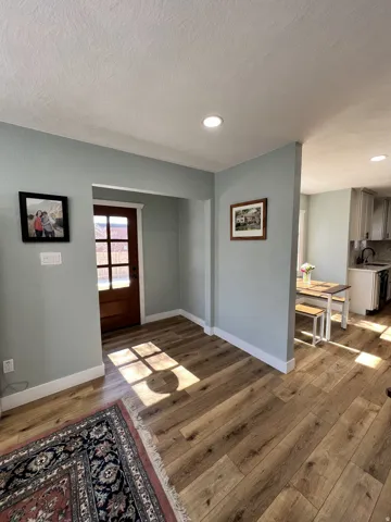 Wood-finish flooring throughout, recessed lighting, and light blue wall tones
