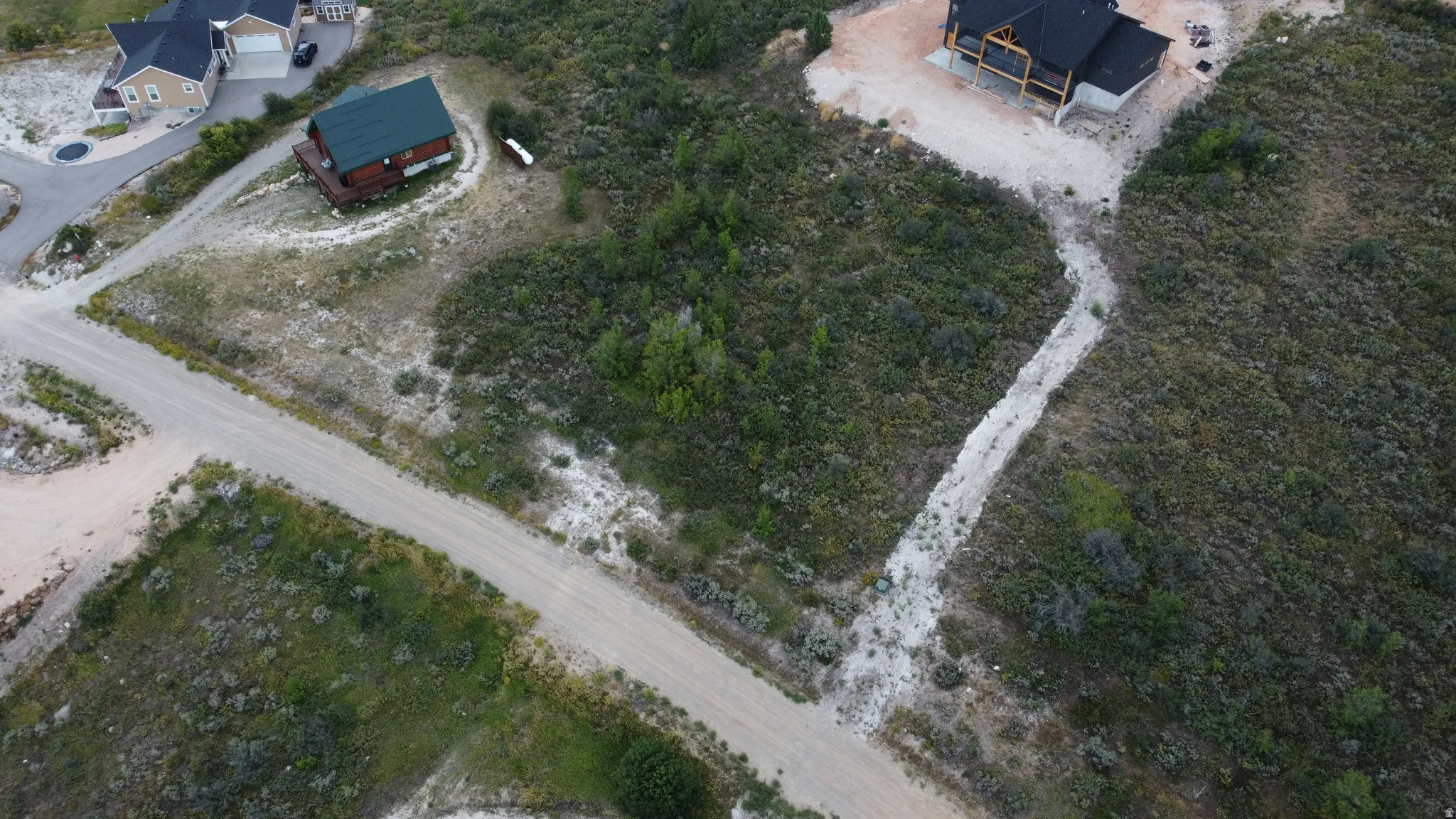 Expansive land parcel featuring natural terrain and a partial dirt road