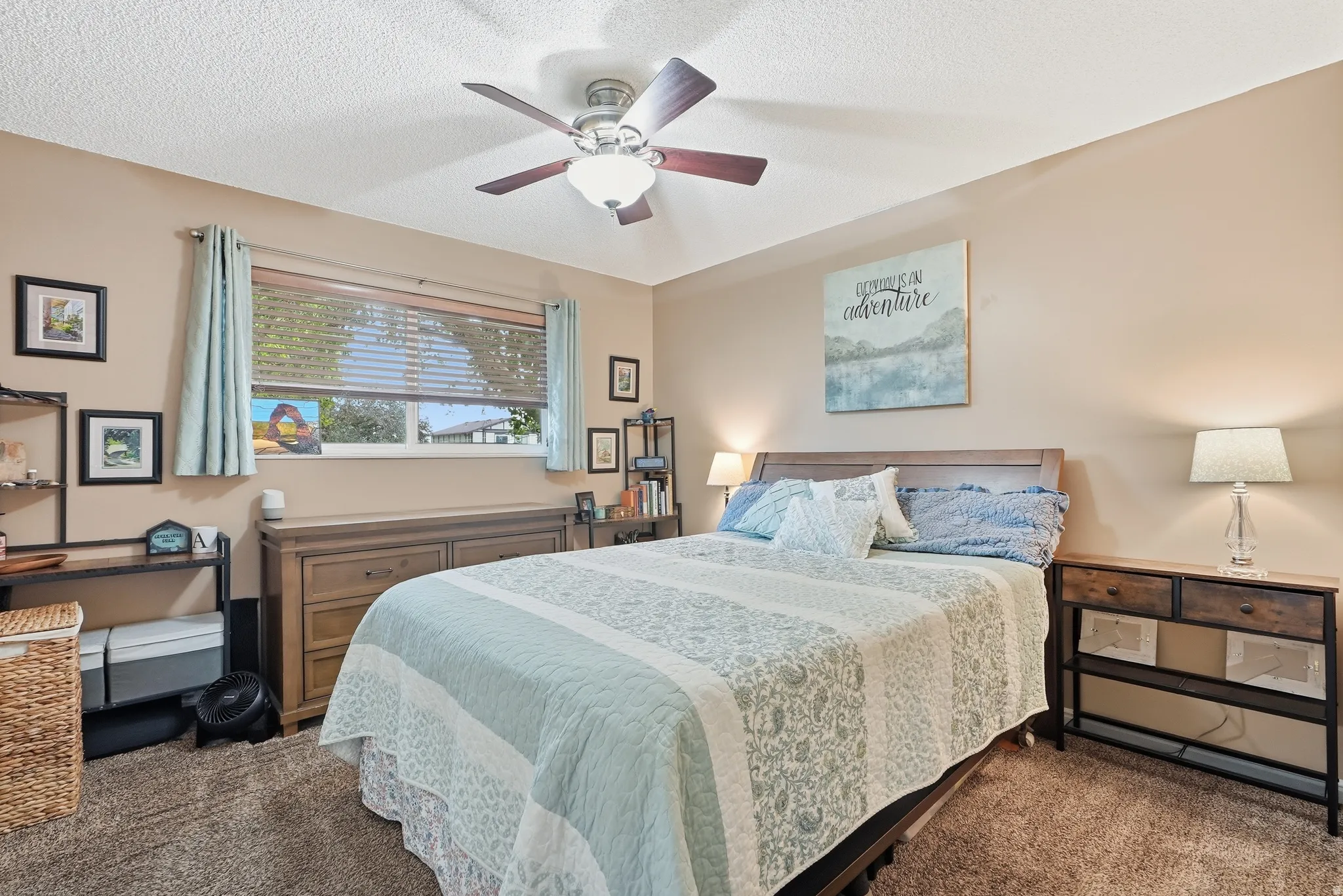 Ceiling fan with integrated lighting, window with horizontal blinds, built-in wooden headboard, and textured wall finish