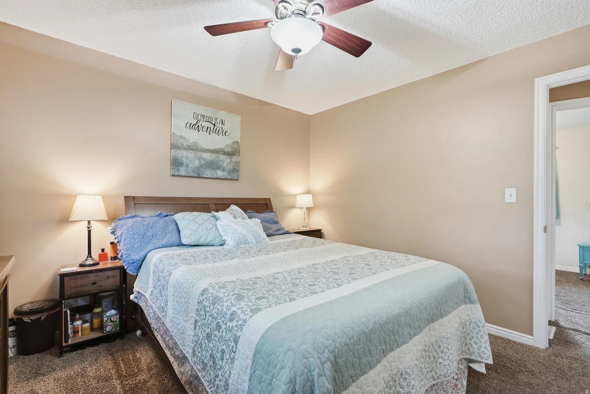 Recessed ceiling fan with wood-finish blades, soft brown wall color, and textured carpet flooring
