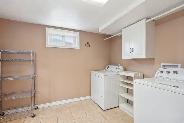 Tiled flooring, white wall-mounted cabinetry, and a window with white trim