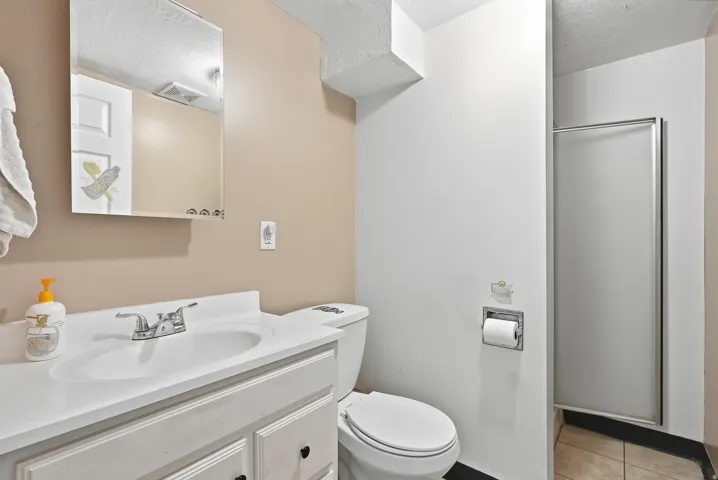 Bathroom featuring a vanity with a white countertop and integrated sink, chrome-finish faucet, and a wall-mounted mirrored cabinet