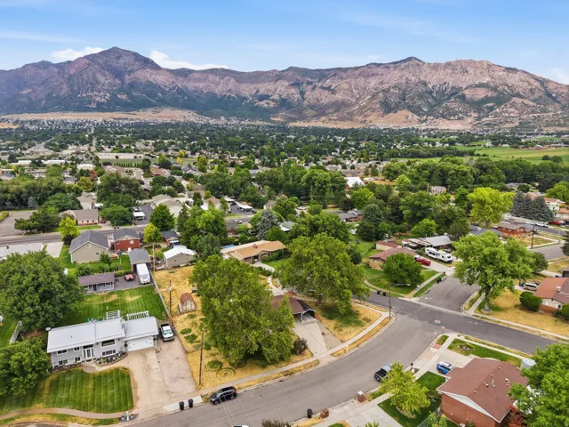 Mountain backdrop, residential neighborhood, mature trees, paved streets, single-family homes