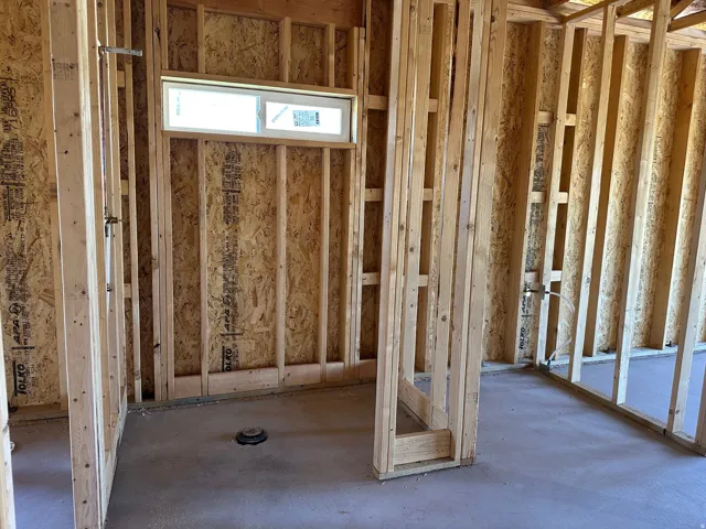New construction framing with a horizontal window and concrete slab flooring