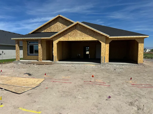 Single-story new construction featuring a covered entry, concrete porch, and a multi-car garage