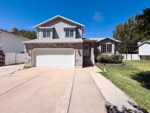 Two-story home featuring a brick and siding exterior with a prominent front-facing garage