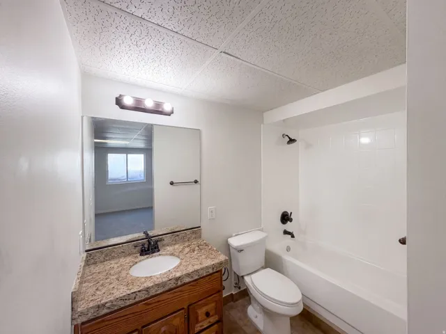 Vanity with granite-look countertop, undermount sink, and dark bronze-finish fixtures