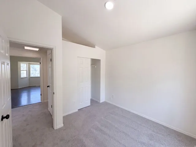 Recessed lighting, light-colored carpeting, white interior doors, and white walls