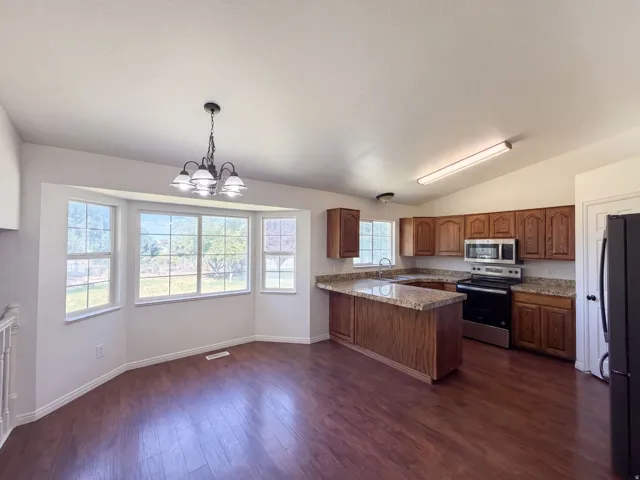 Kitchen featuring wood-finish cabinetry, speckled countertops, and stainless steel appliances