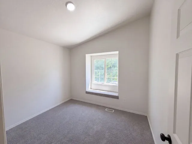 Vaulted ceiling, recessed lighting, double-hung window, window seat, and gray carpeting
