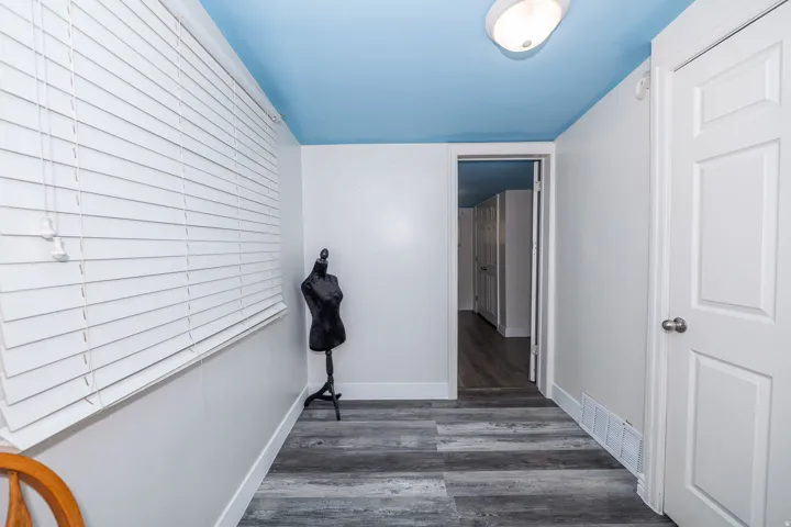 Wood-finish flooring, white walls, and a light blue ceiling