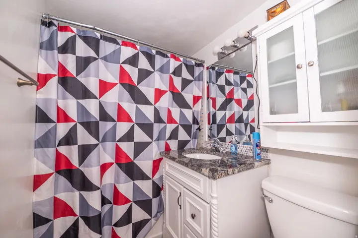 White vanity with a granite-style countertop and an integrated sink
