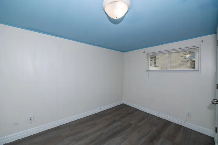 Wood-finish flooring with white trim and a recessed window