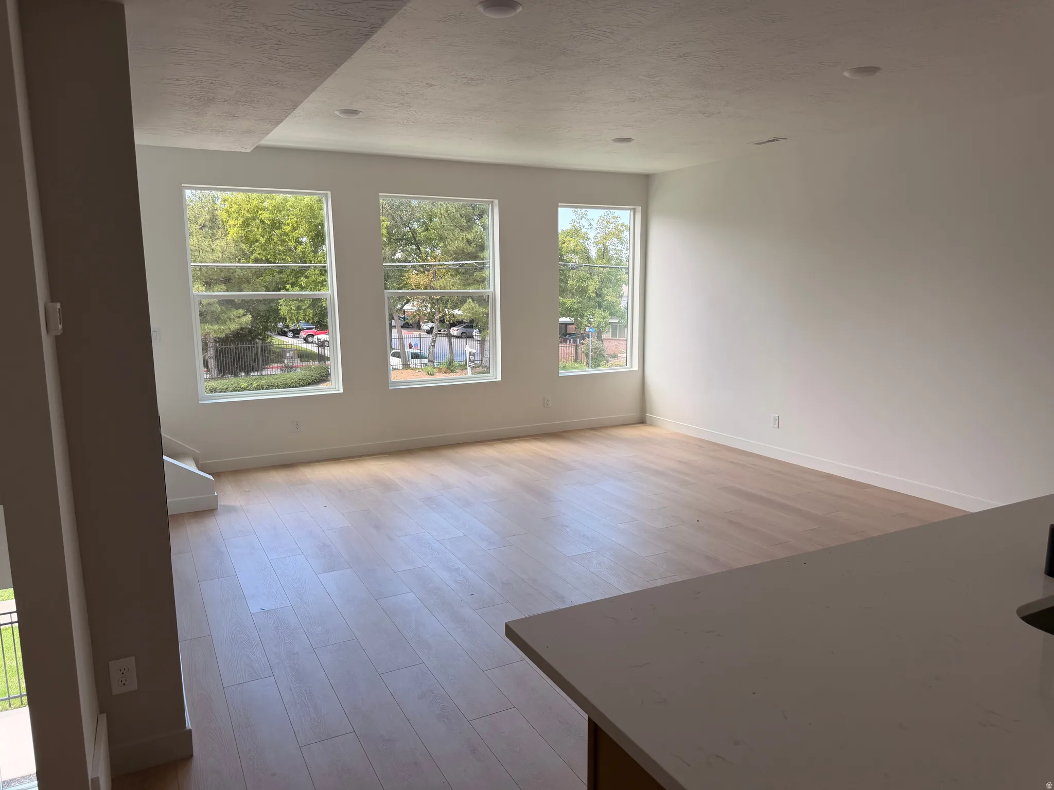 Wood-finish flooring, recessed lighting, and multiple windows with white trim