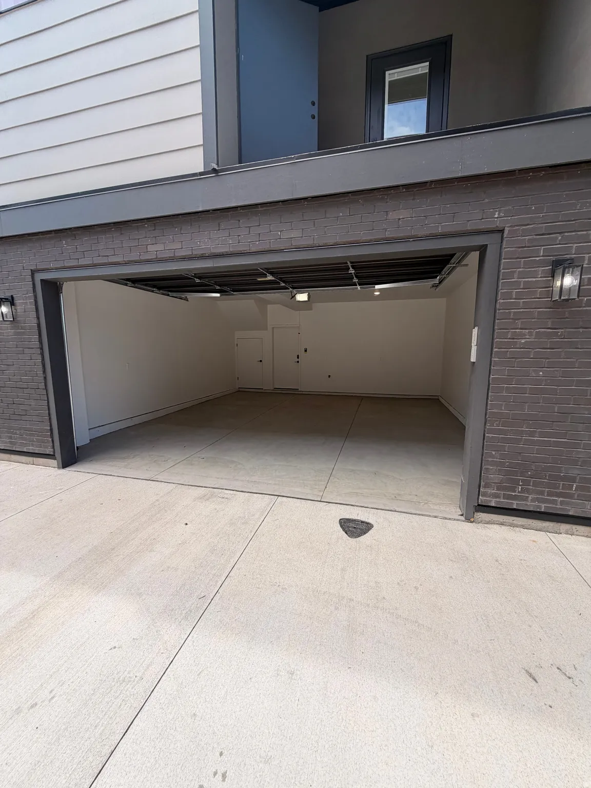 Integrated garage with concrete flooring, recessed lighting, and white walls