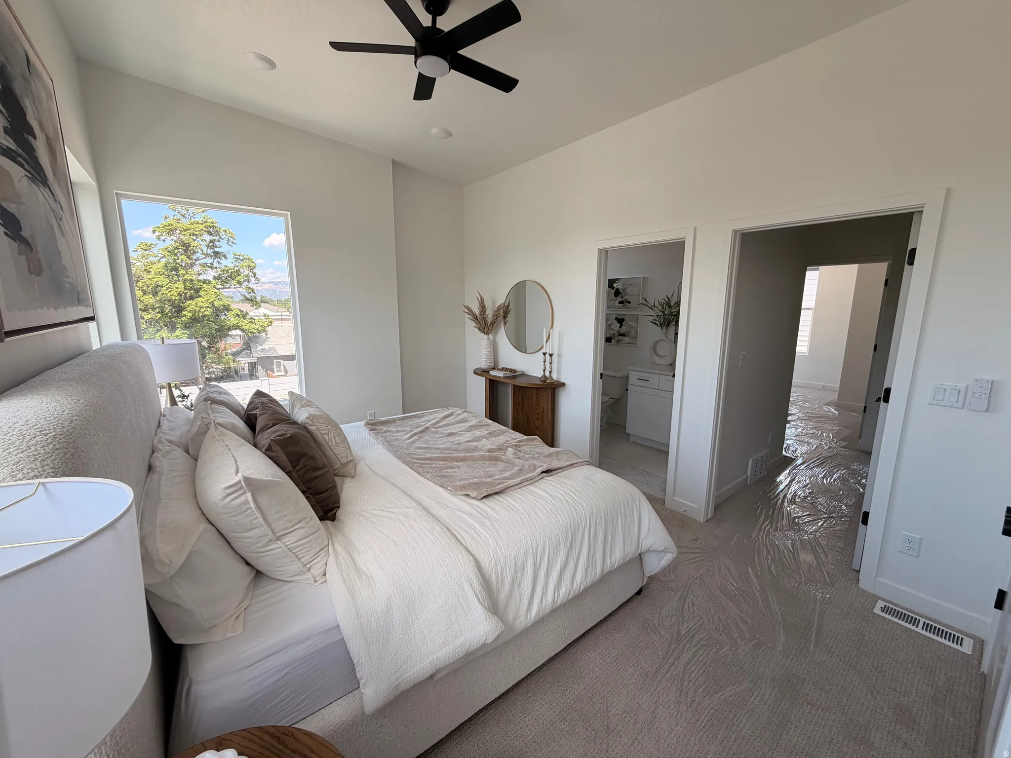 Expansive window, vaulted ceiling, and ceiling fan in bedroom