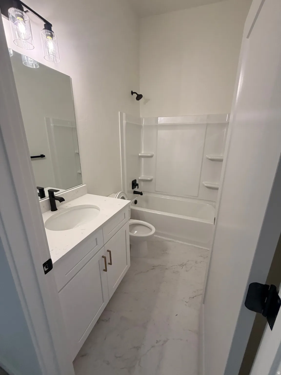 Bathroom featuring a white vanity with gold-tone hardware, a white undermount sink, and a white countertop