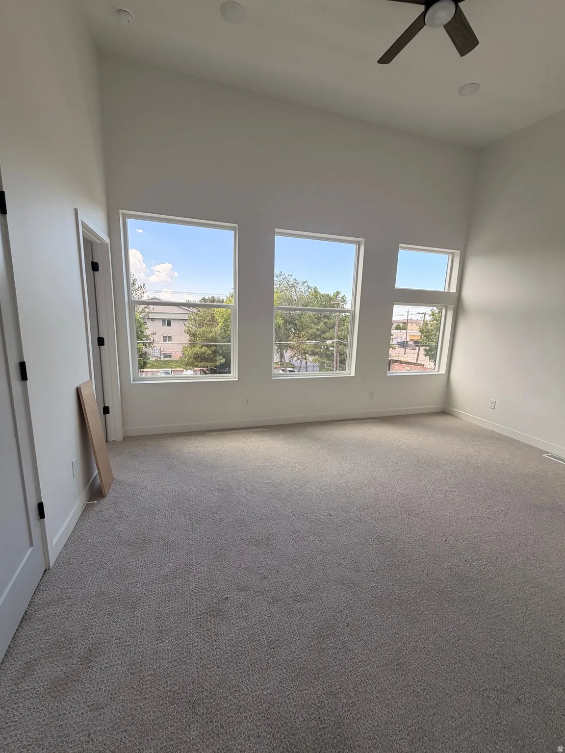 Vaulted ceiling, multiple windows, recessed lighting, ceiling fan, and light-toned carpeting
