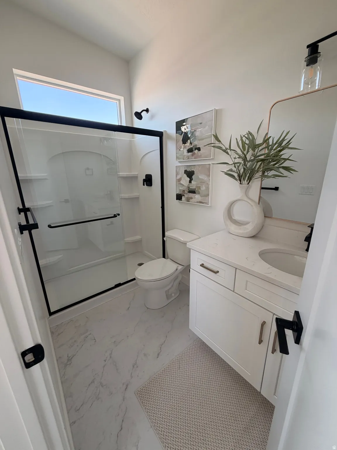 White shaker vanity with a stone-finish countertop and undermount sink