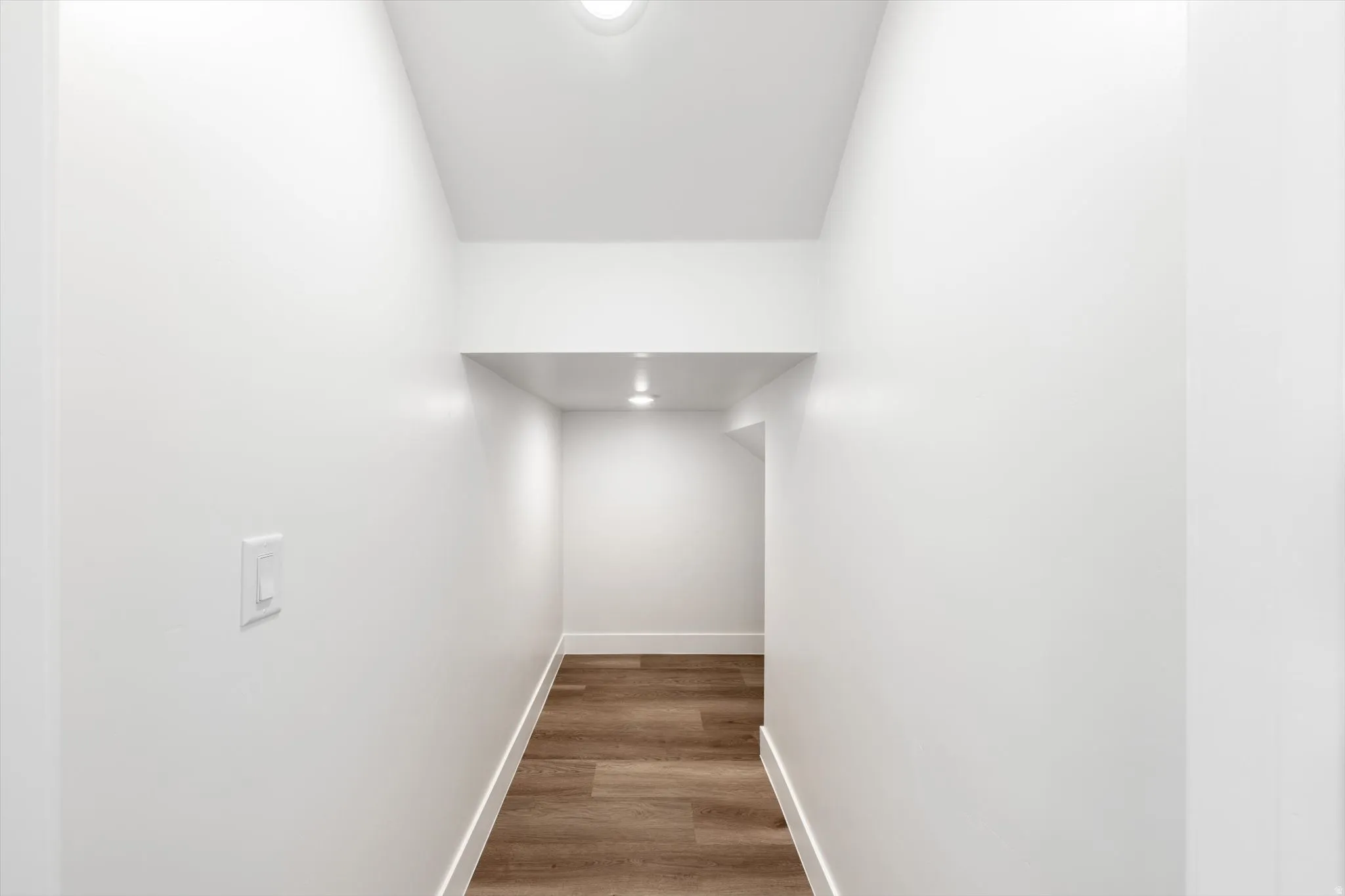 Recessed lighting, light wood-finish flooring, white walls, and built-in shelving