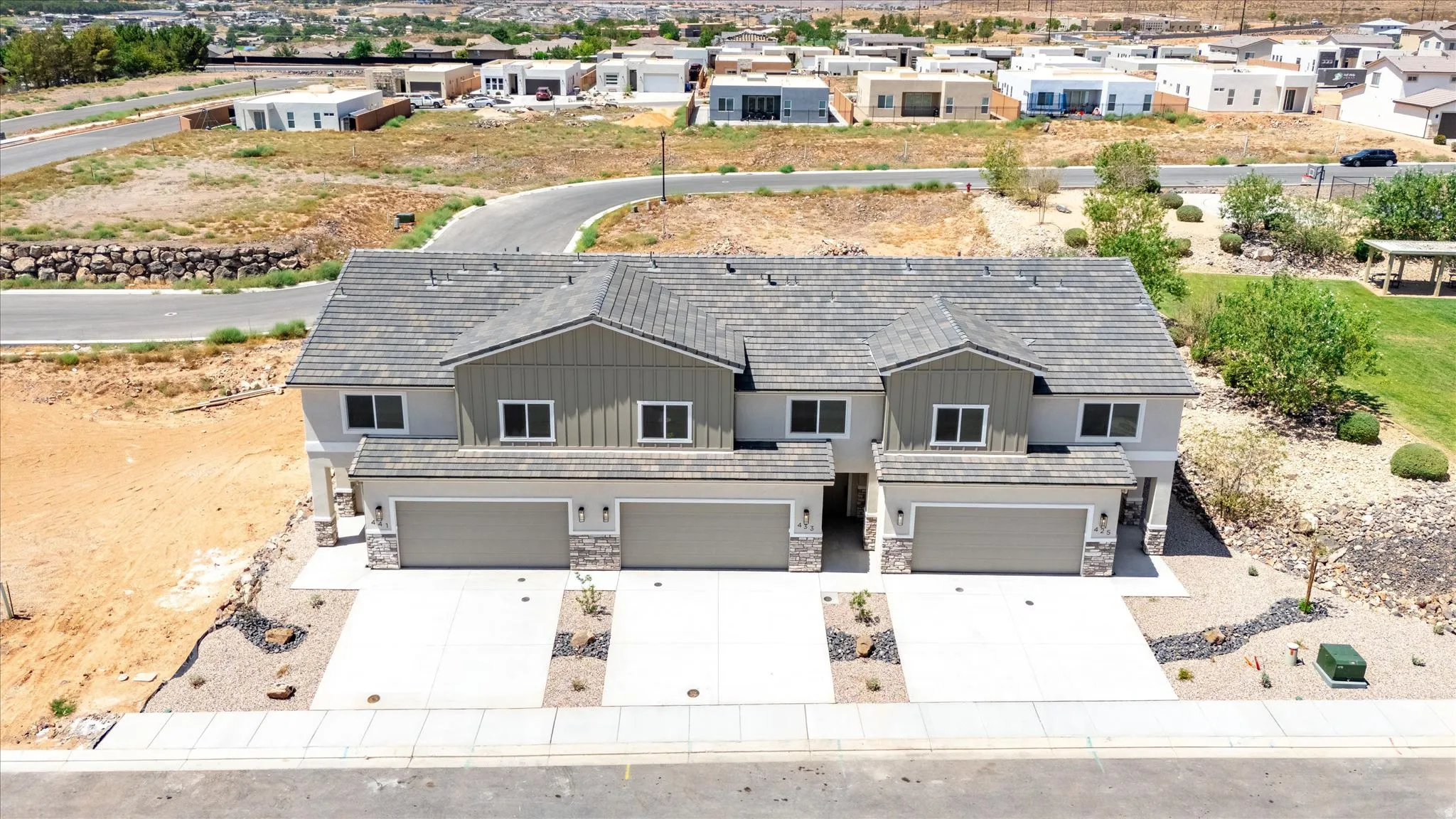 Multi-unit residential structure featuring a gray tiled roof and light gray siding