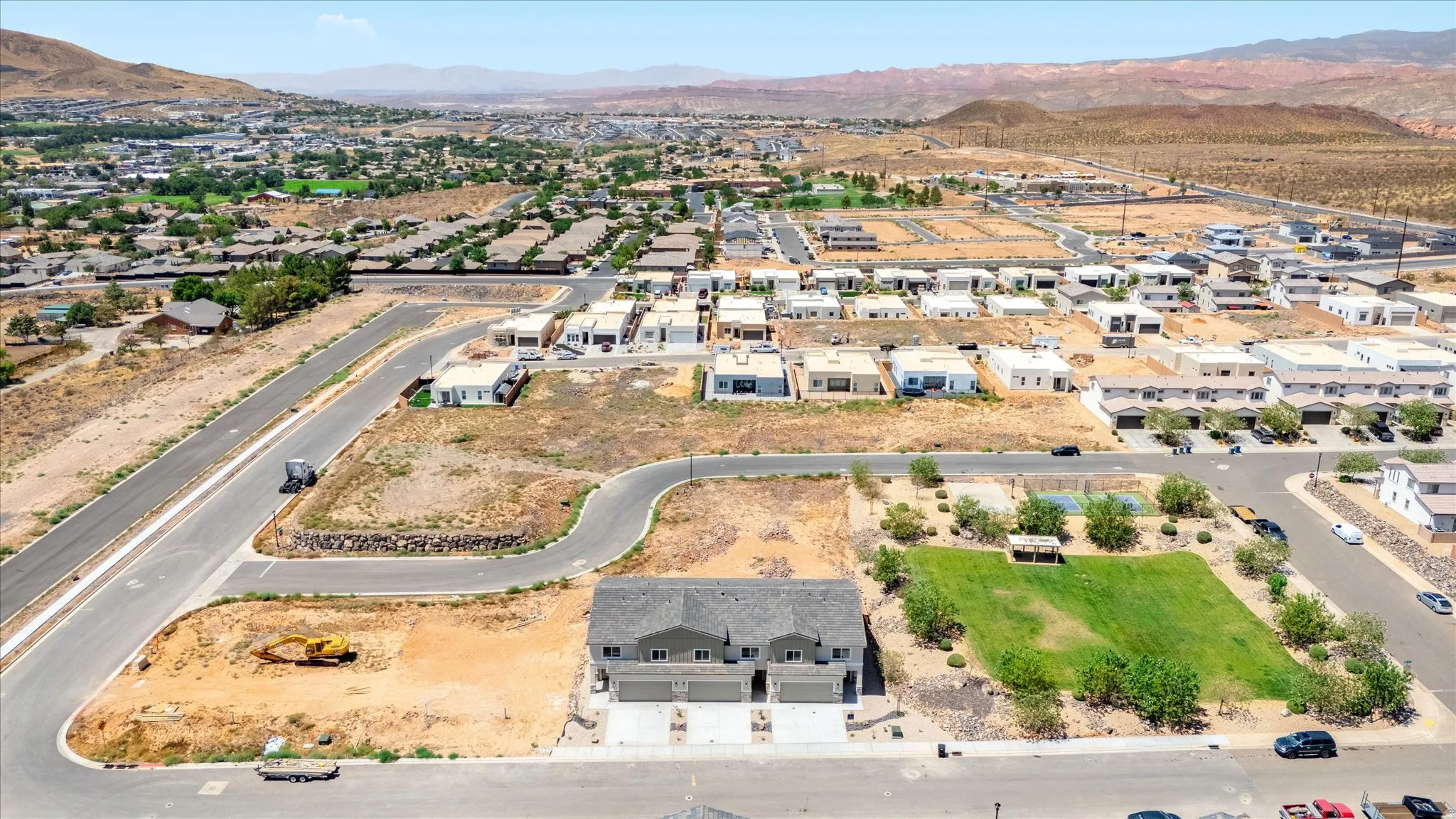 Newly constructed duplex property featuring an attached two-car garage and a paved driveway