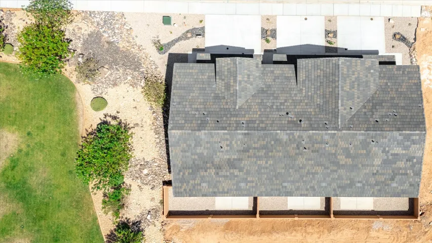 Architectural shingle roofing with varied tones, multiple roof planes, and an attached side-by-side garage