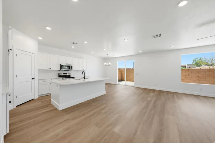 Open-concept living area featuring wood-finish flooring, recessed lighting, and a modern kitchen