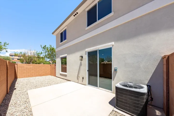 Private patio space featuring a concrete slab and gravel landscaping