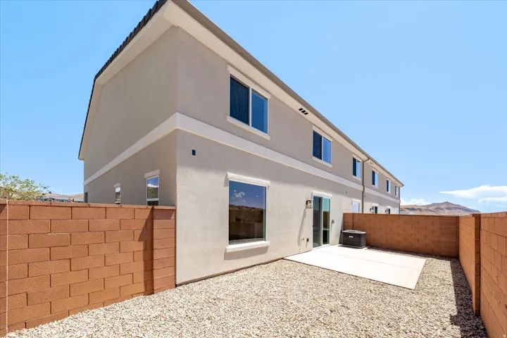 Private yard featuring a concrete patio, gravel landscaping, and block walls