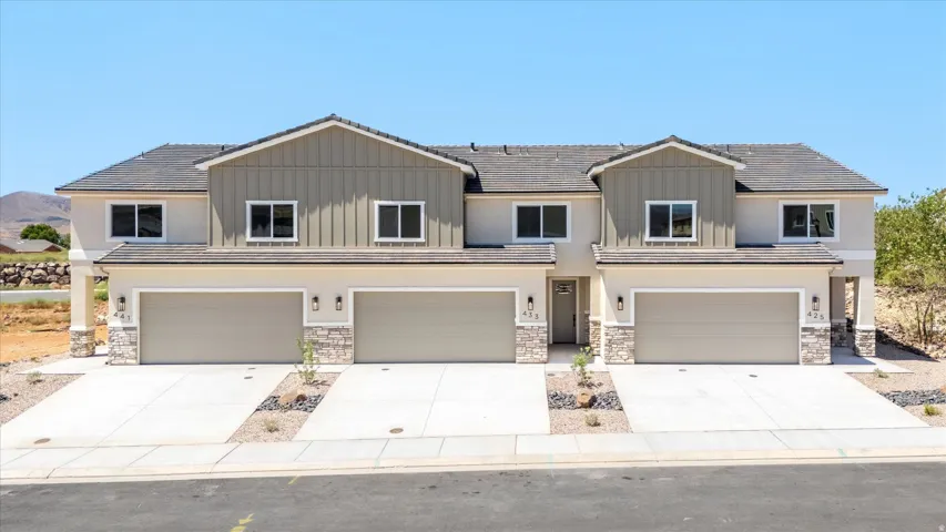 Modern townhome exterior featuring stucco and vertical siding accents