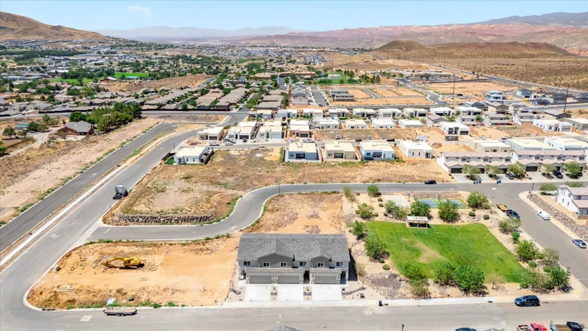Newly constructed duplex property featuring an attached two-car garage and a paved driveway