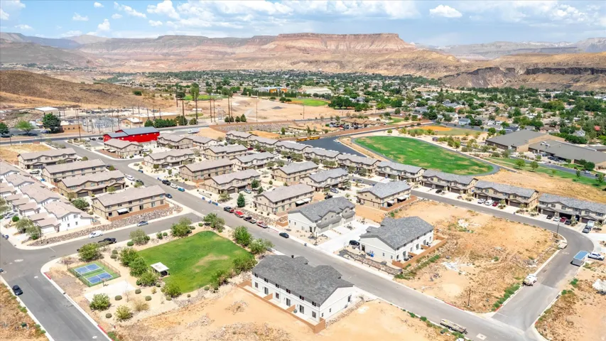 Residential community featuring multi-story properties, arid landscaping, and a mountainous backdrop