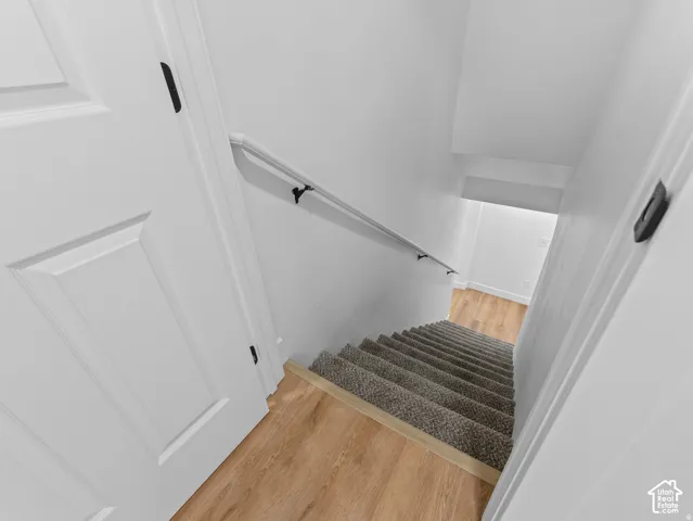 Staircase with carpeted treads and a black metal handrail