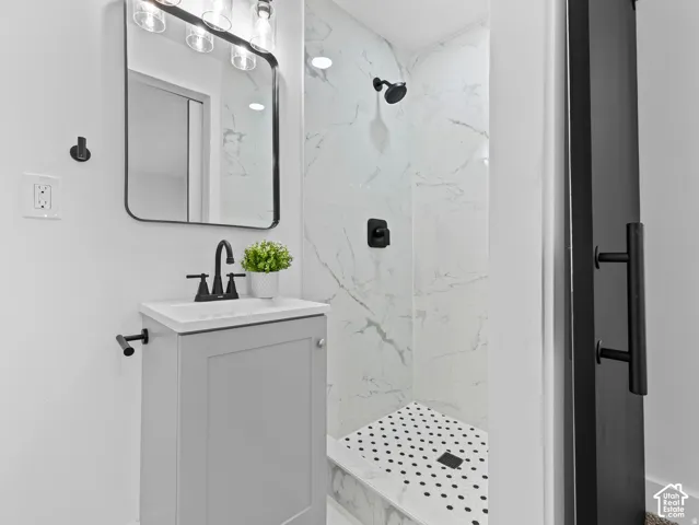 Vanity with a single basin, matte black faucet, and light gray cabinetry