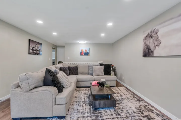 Recessed ceiling lighting, light gray wall paint, wood-finish flooring, and a flush mount ceiling light