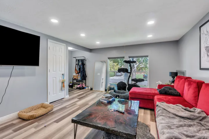 Recessed lighting, wood-finish flooring, and white trim