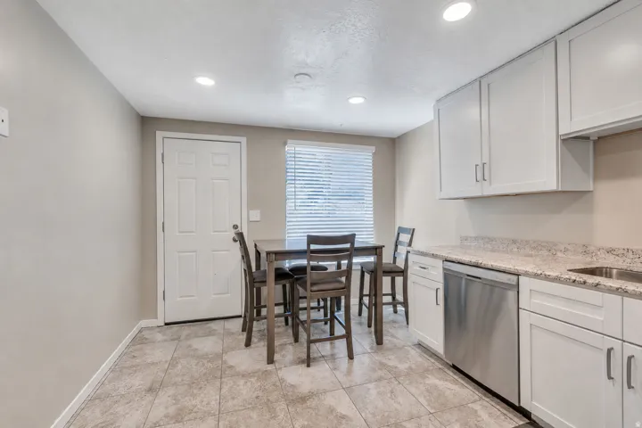 Kitchen featuring white cabinetry, light-colored countertops, stainless steel dishwasher, tile flooring, and recessed lighting