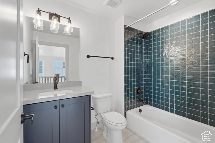 Bathroom featuring a single vanity with a gray countertop, dark cabinetry, and bronze hardware