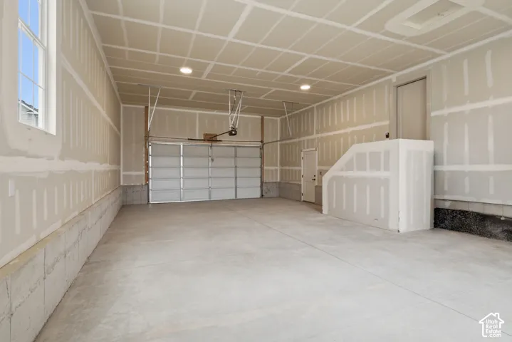 4 Car garage! Spacious garage with a concrete floor, overhead garage door, and recessed lighting
