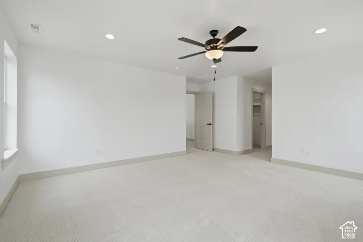 Primary Suite. Spacious room featuring carpet flooring, recessed lighting, and a ceiling fan with integrated light