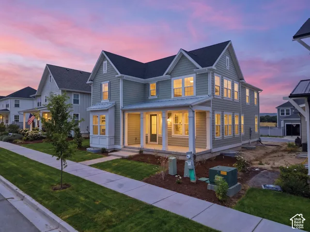 Two-story residence featuring light gray siding, white trim, and a dark shingled roof